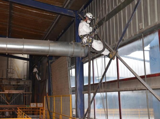 Cordiste en intervention dans un hall industriel